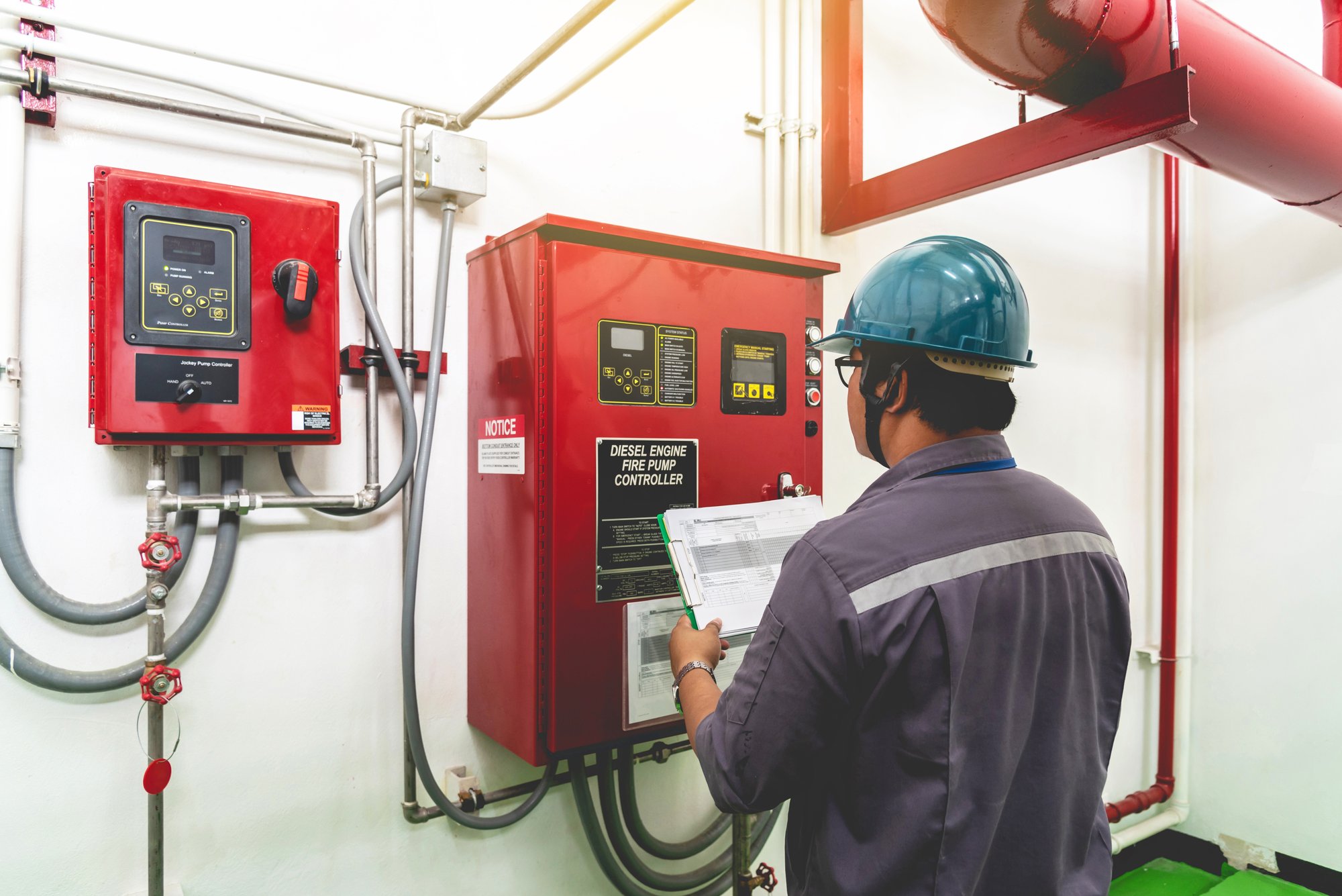 Worker looking at fire system control panel Worker looking at fire system control panel