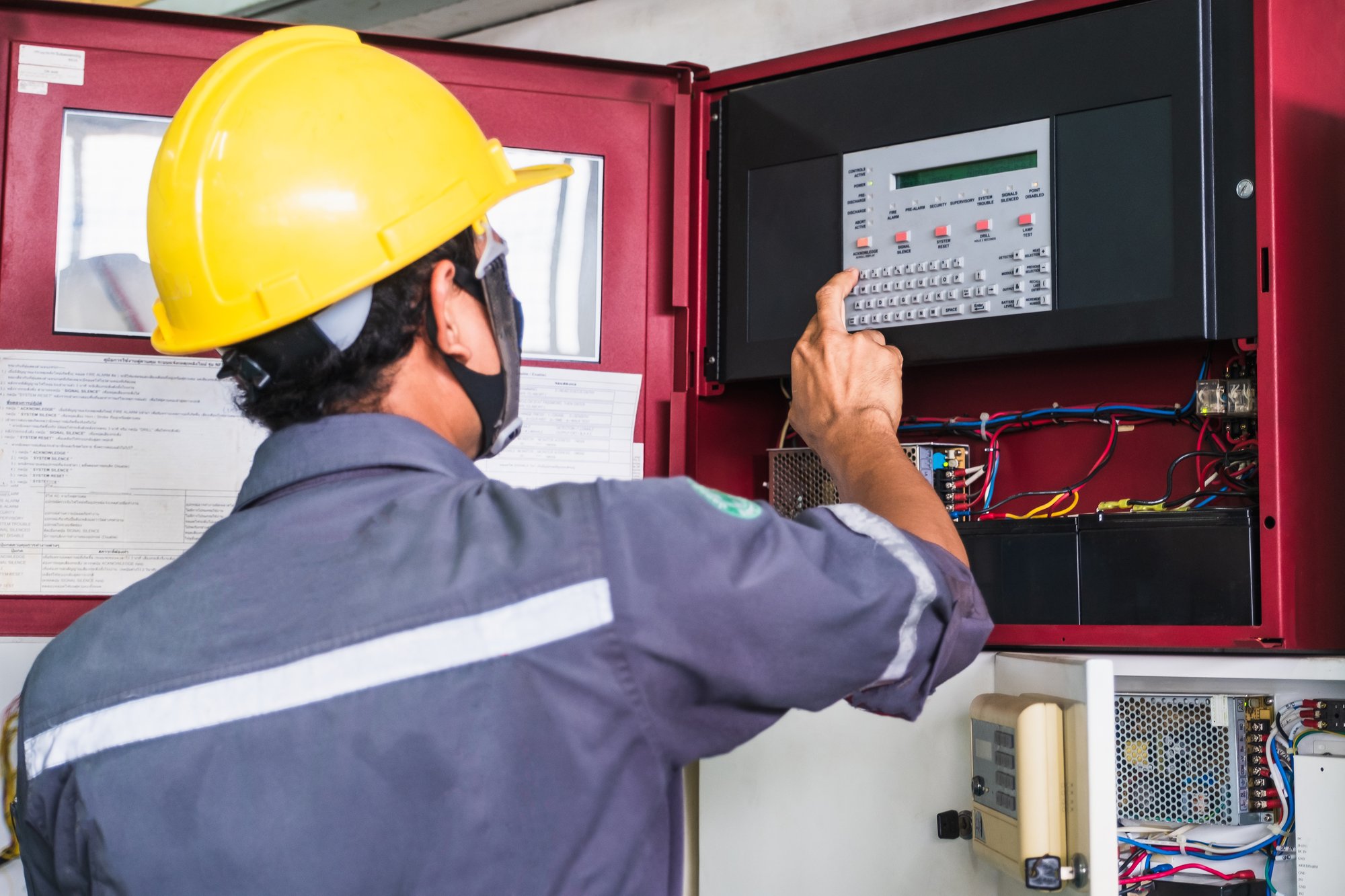 Worker technician working on fire alarm system Worker technician working on fire alarm system
